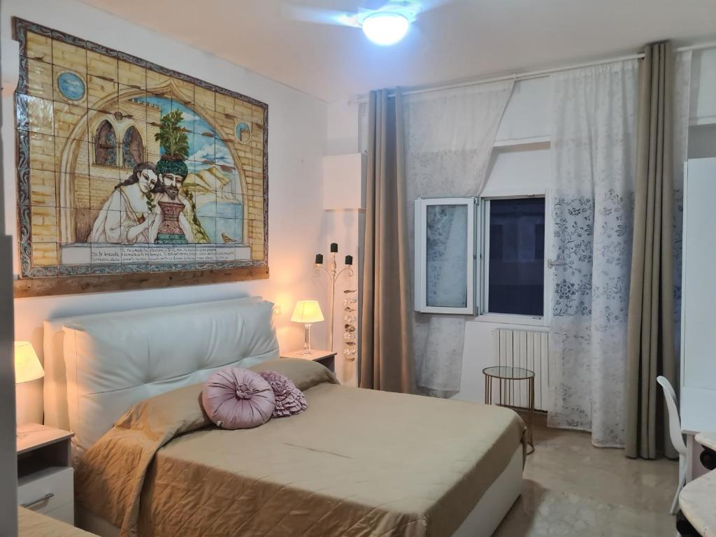 a bedroom with a bed and a painting on the wall at Ruggero Settimo Prestige in Palermo