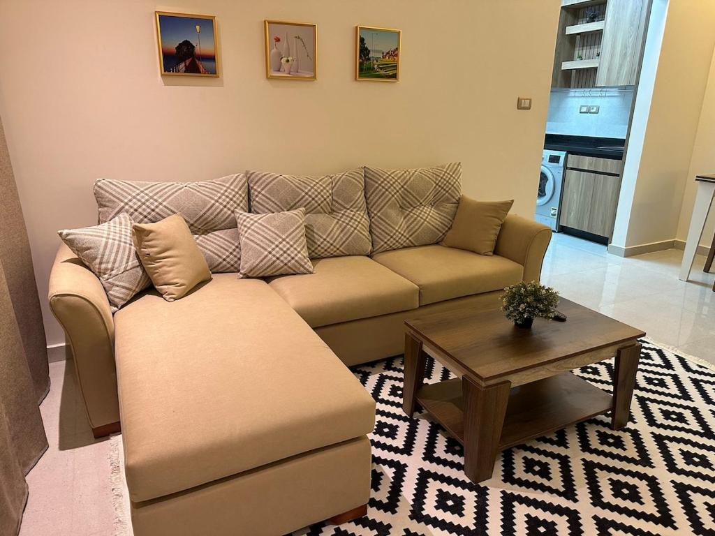 a living room with a couch and a coffee table at Bisan Apartment in Madinat Al Ashir min Ramadan