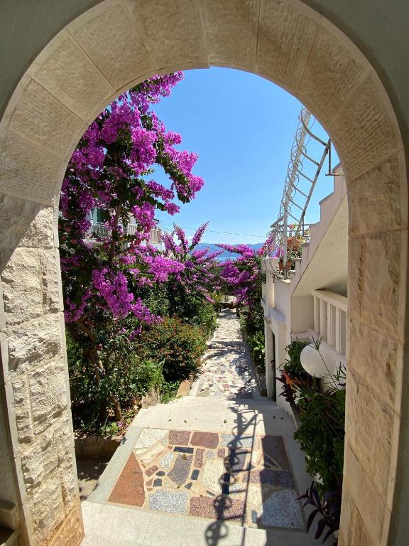 an archway with purple flowers on a building at Apartments Nada in Sućuraj