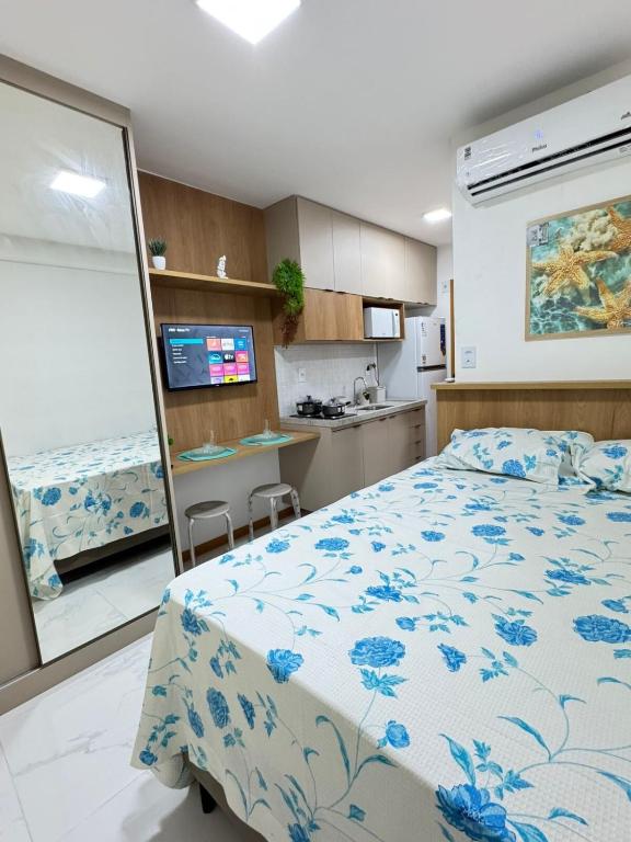 a bedroom with a bed and a kitchen at Smart Convenções in Salvador