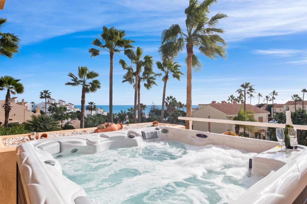 a hot tub with palm trees and the ocean at Penthouse with Jacuzzi by Costarentals - Ref 244 in Fuengirola