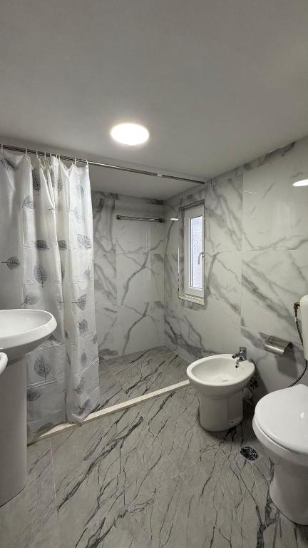 łazienka z umywalką i toaletą w obiekcie Guesthouse Makry w mieście Pukë