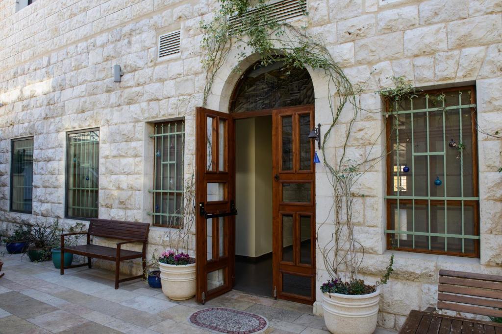 uma entrada para um edifício de pedra com uma porta de madeira em Villa Nazareth B&B na Nazaré