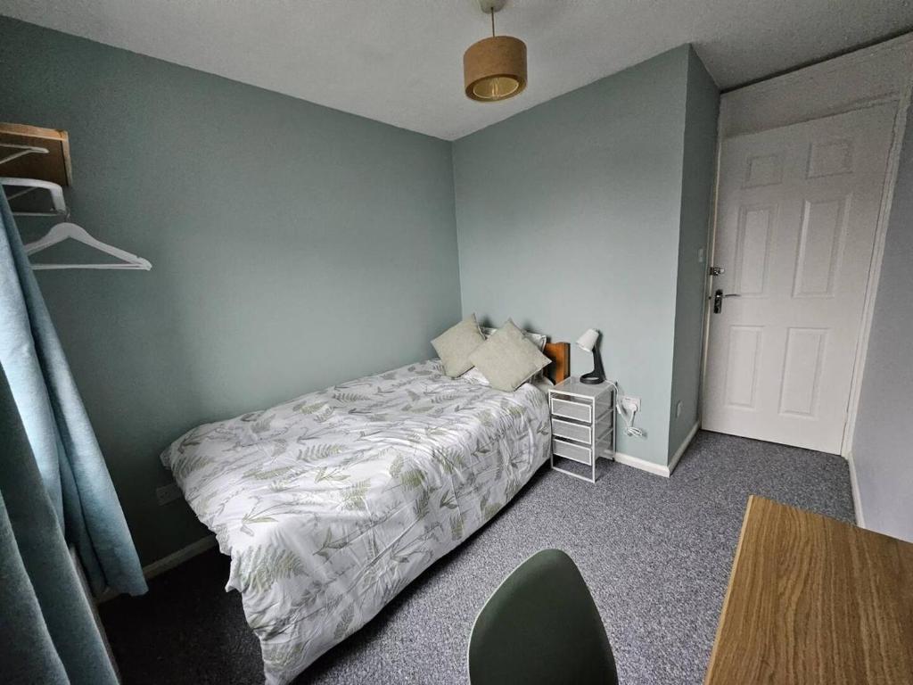 a bedroom with a bed and a table with a chair at Inspire Home Stylish Stay D in Cardiff