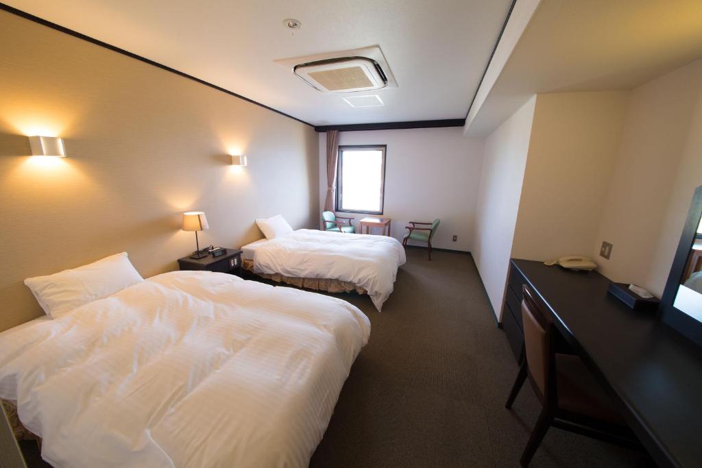 Postel nebo postele na pokoji v ubytování Seaside Hotel Taimaru Kaigetsu
