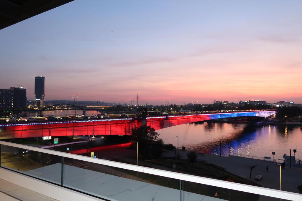 un puente sobre un río con una ciudad por la noche en Calisi Hotel, en Belgrado