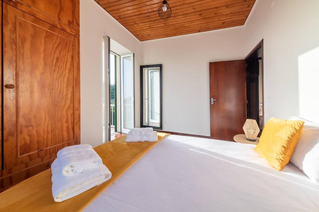 a bedroom with a large white bed with a wooden headboard at João Loft I by Mth in Campanário