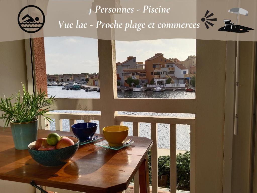 une table avec un bol de fruits sur un balcon dans l'établissement Cocon Marine-Piscine-Vue Lac-Restaurants, commerces-Calme, au Barcarès