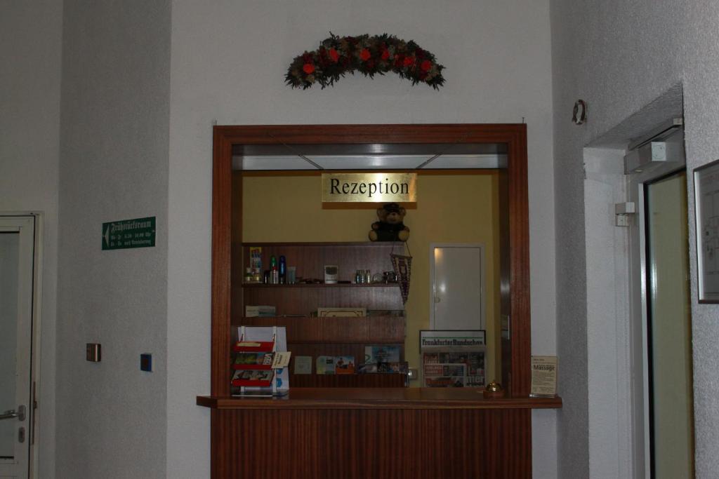 a shop with a reception sign in a room at Gasthaus &amp; Hotel Grünhof in Frankfurt Oder
