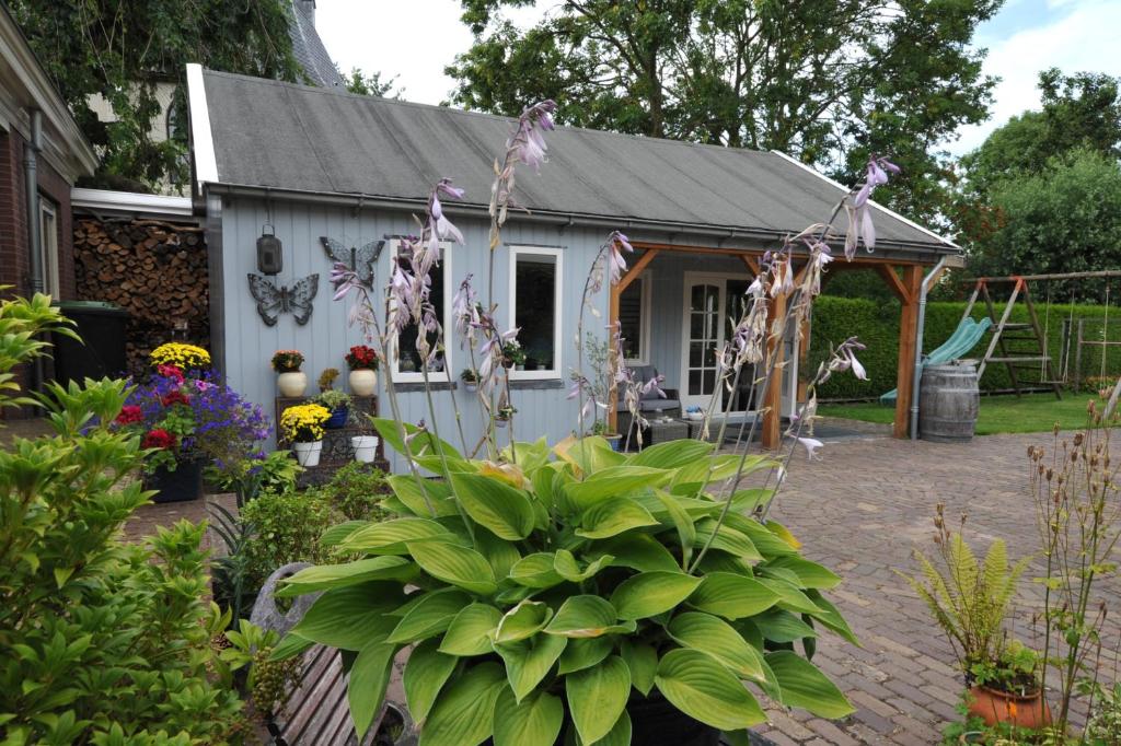 um barracão branco com uma mesa e cadeiras num jardim em Di'Mami House em Avenhorn