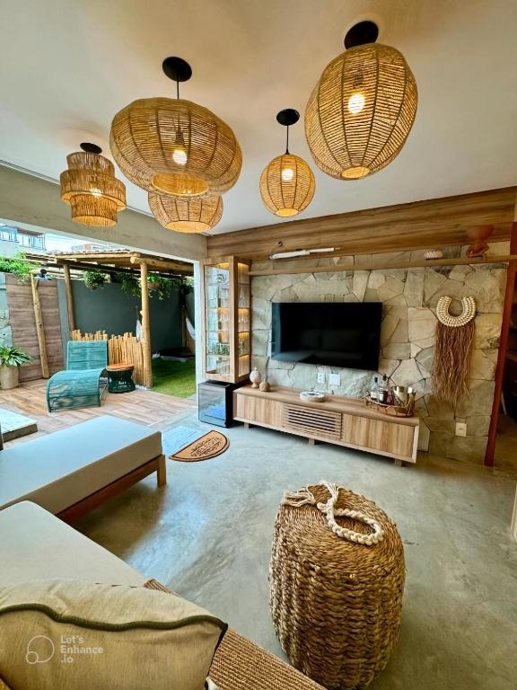 a living room with a couch and a tv and some lights at Seaesta Milagres in São Miguel dos Milagres