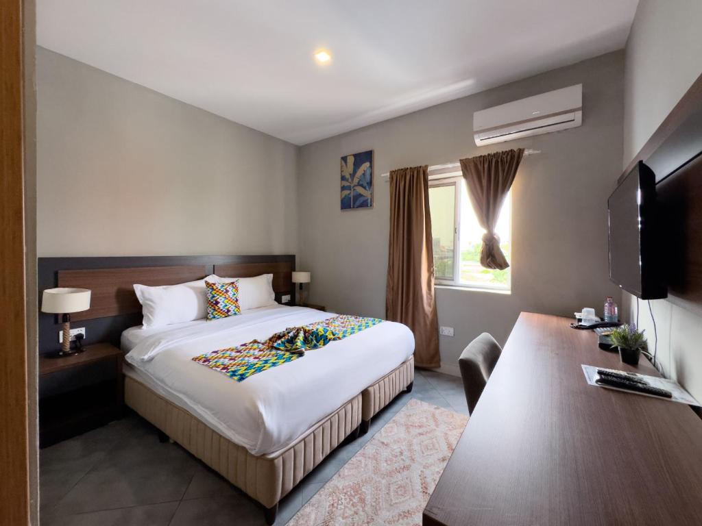 a hotel room with a bed and a television at Euro Homes Hotel in Accra