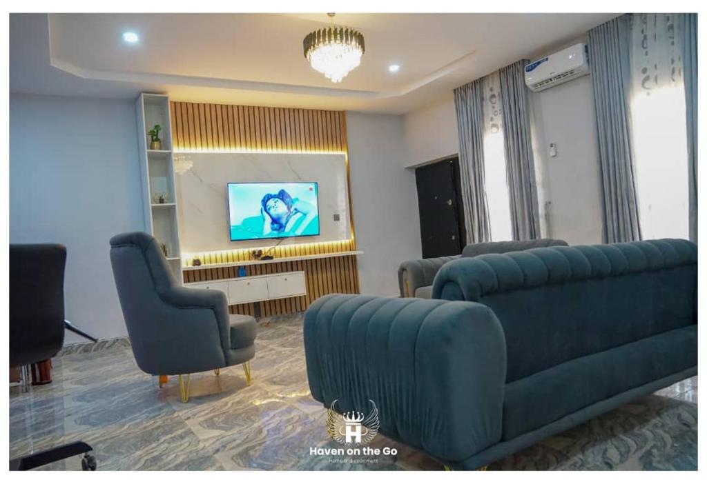 a living room with a couch and chairs and a television at Luxury 3bedroom in Serene Estate Kubwa FCT in Kubwa