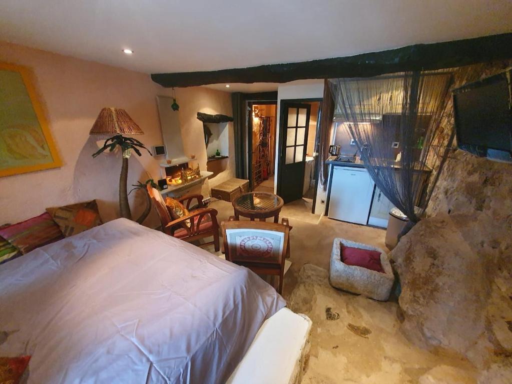 a bedroom with a large bed and a living room at Charmant Appartement au Broc in Le Broc