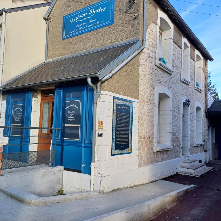 un bâtiment avec une porte bleue dans une rue dans l'établissement L'Epicerie Maison années 30, à Caen