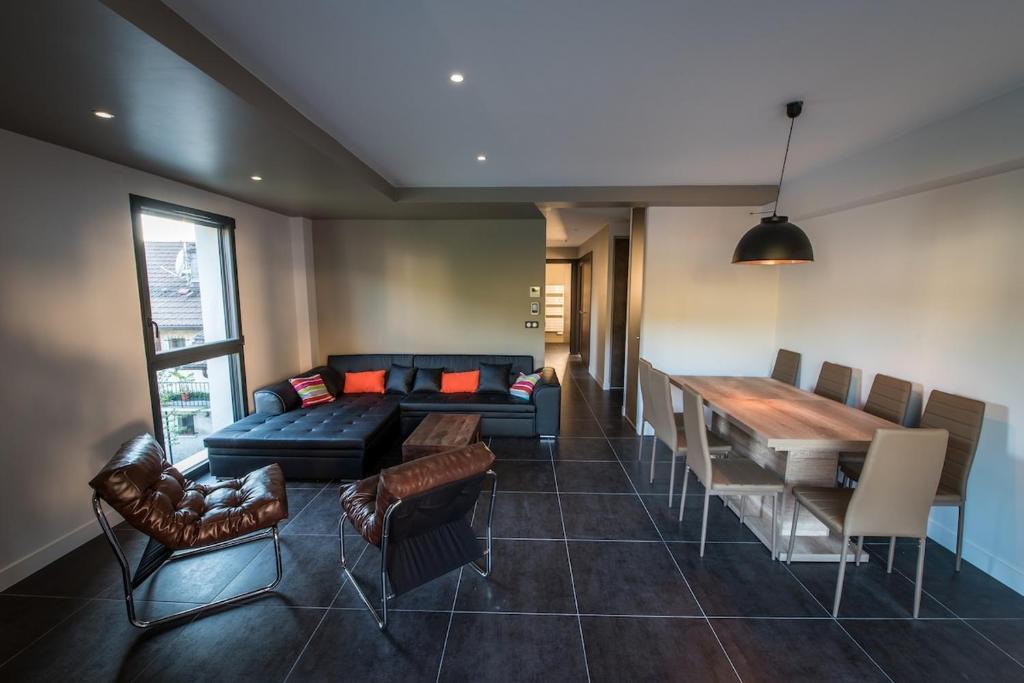 un salon avec un canapé, une table et des chaises dans l'établissement La Prairie, à Annecy