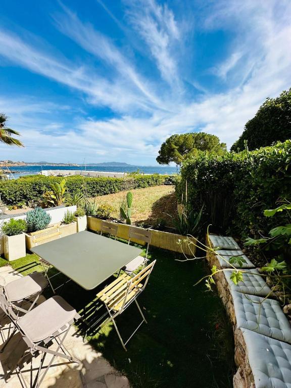 un patio avec une table et des chaises et une vue sur l'océan dans l'établissement Appartement 6 pers - Port privée - Plage privée - Piscines - Tennis, à Bandol