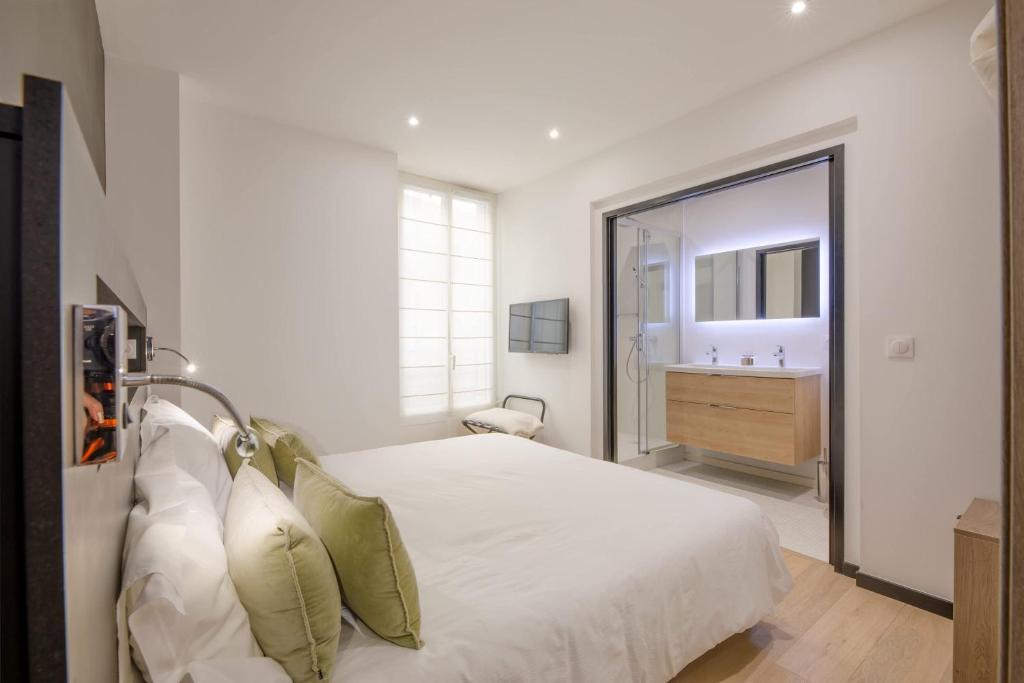- une chambre blanche avec un grand lit et un lavabo dans l'établissement Scandinavian Urban 1 - 2BR apartment in center close to Palais des Festivals and the beach, à Cannes