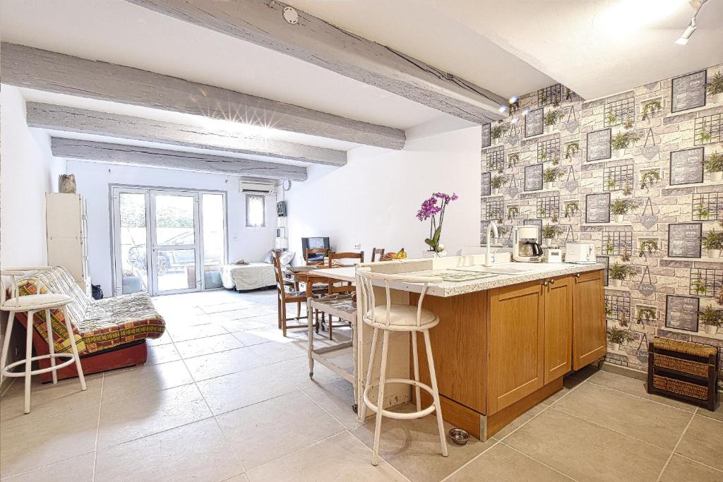 une cuisine avec un comptoir, une table et des chaises dans l'établissement Appartement au coeur de Vendémian, à Vendémian