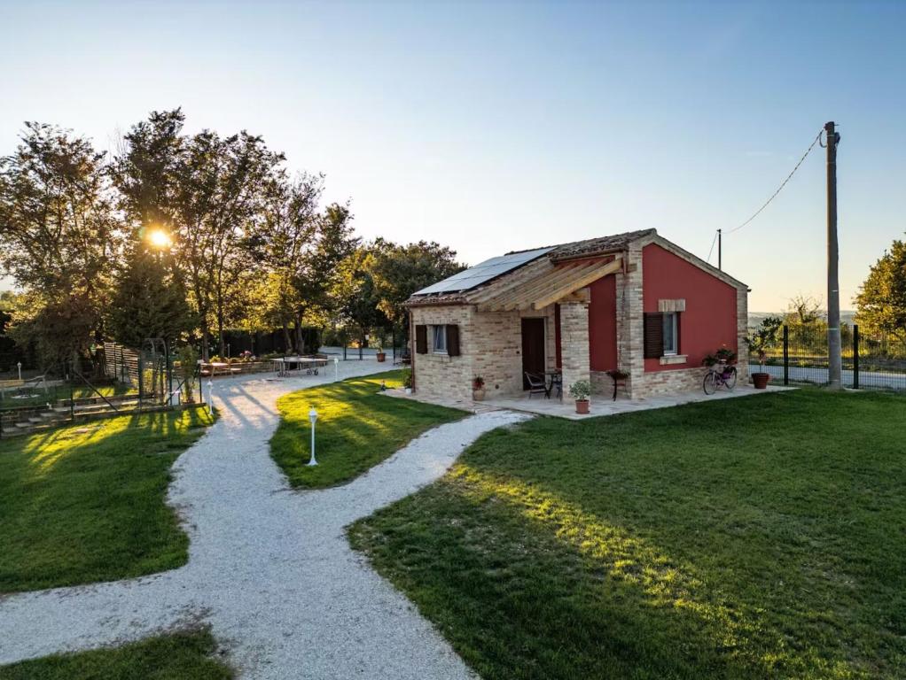 a small brick building with a pathway leading to a yard at I Colori dell'Infinito in Recanati