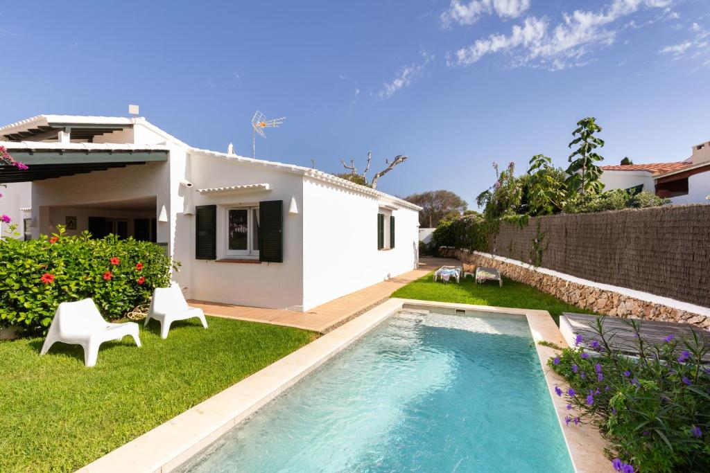a backyard with a swimming pool and a house at Villa Esther vistas al mar Menorca in Cap d'en Font