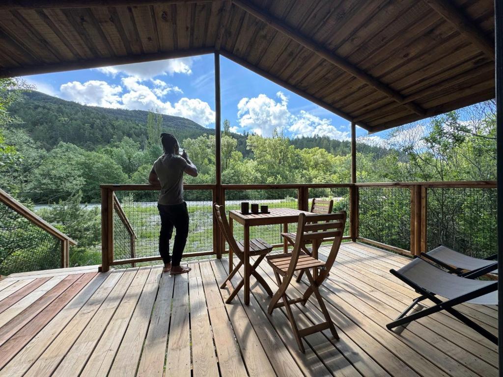 une personne prenant une photo d'une vue depuis une terrasse dans l'établissement Camping L'Ondine de Provence, à La Motte-Chalançon