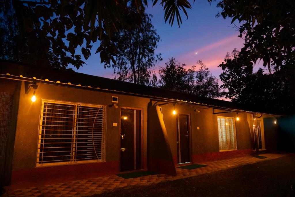 a house with lights on the side of it at night at Wagharanya Resort in Khutwanda