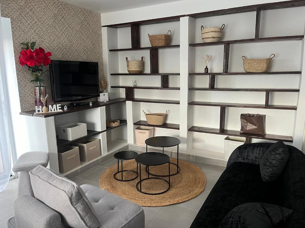 un salon avec deux chaises et une télévision dans l'établissement Maison des Gautraies, à Bécon-les-Granits