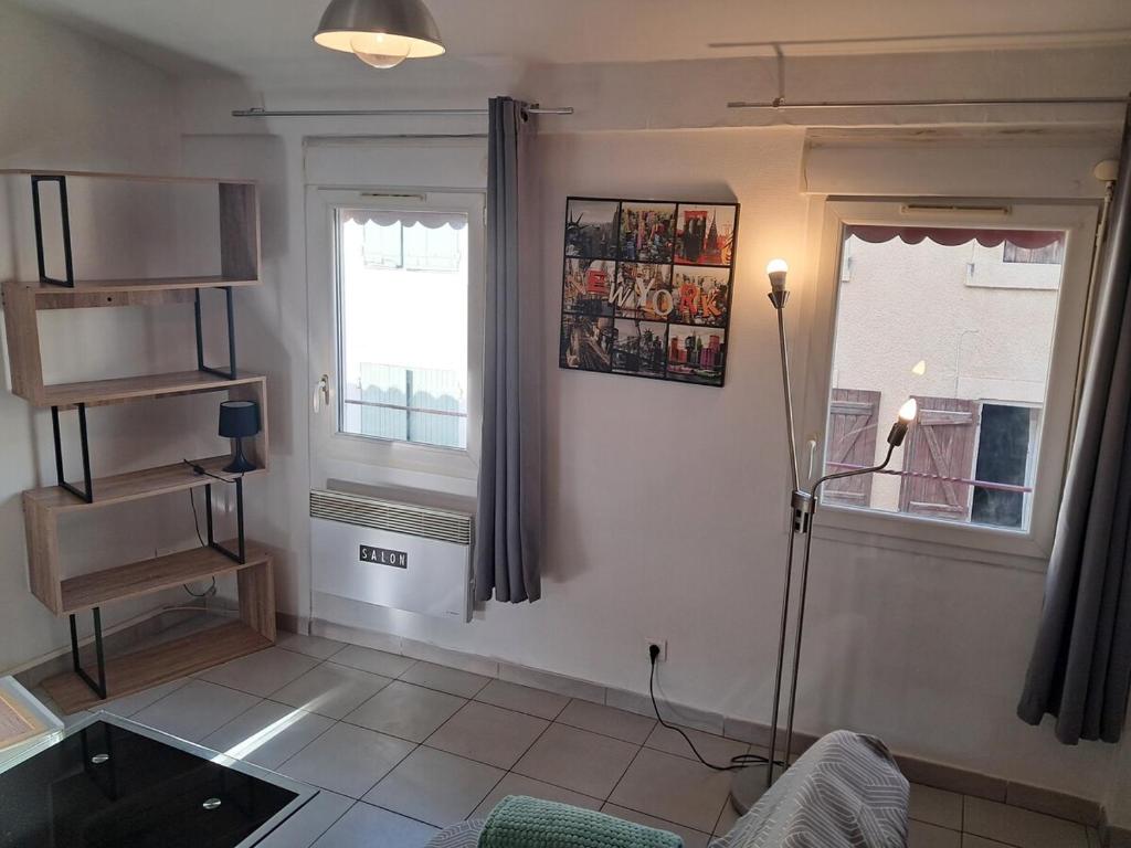 un salon avec un canapé et une fenêtre dans l'établissement le duplex charmant et cosy, à Narbonne