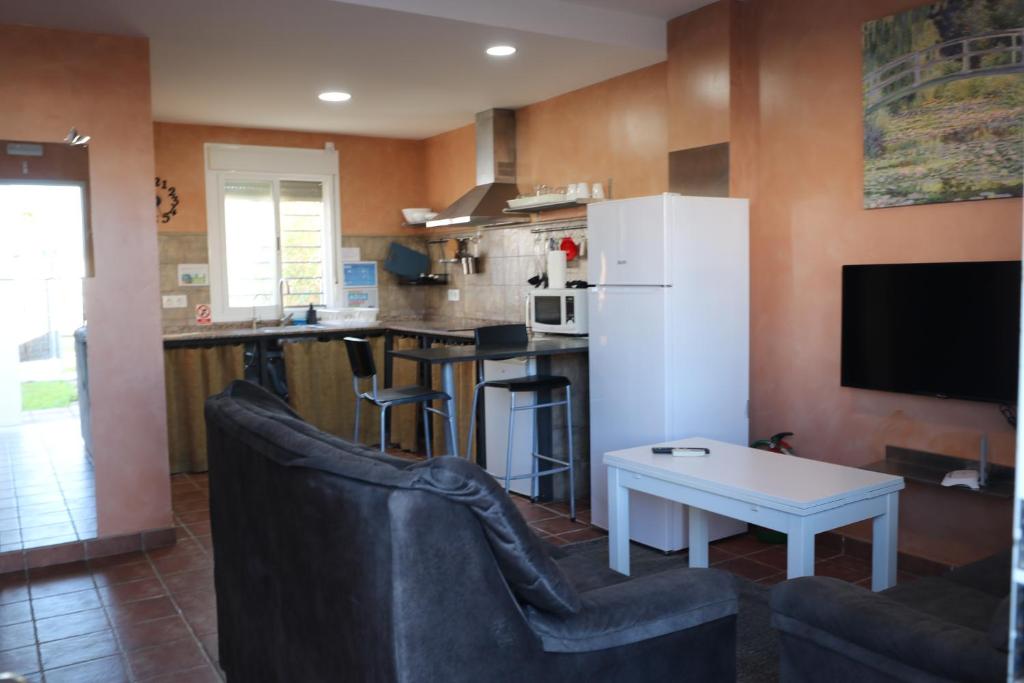 a kitchen with two chairs and a white refrigerator at DADA CAÑOS in Los Caños de Meca