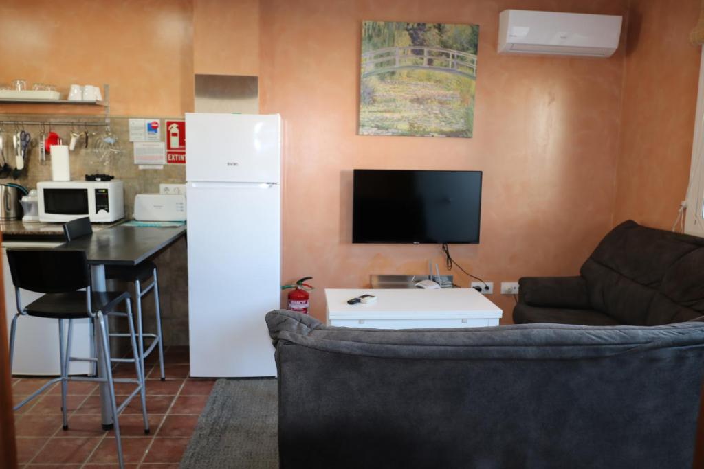 a living room with a white refrigerator and a kitchen at DADA CAÑOS in Los Caños de Meca