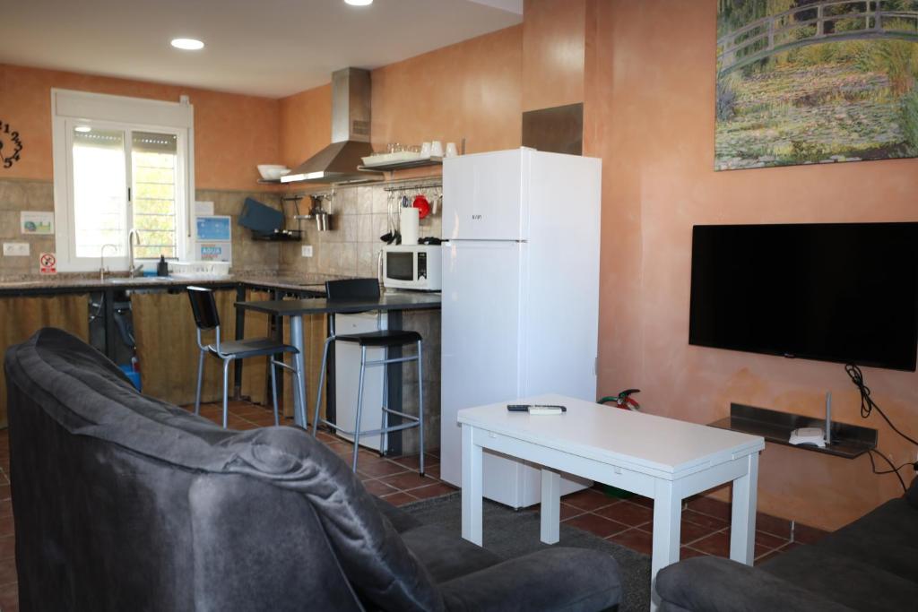 a living room with a white refrigerator and a table at DADA CAÑOS in Los Caños de Meca