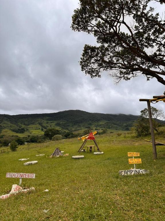 un campo con un albero e segni sull'erba di Complexo canta galo Camping a São Thomé das Letras