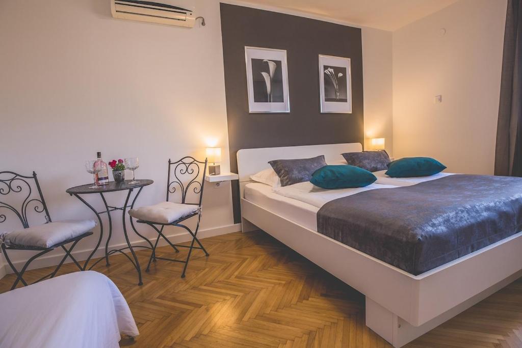 a bedroom with a bed and a table and chairs at Violet Seaview Apartment in Vis