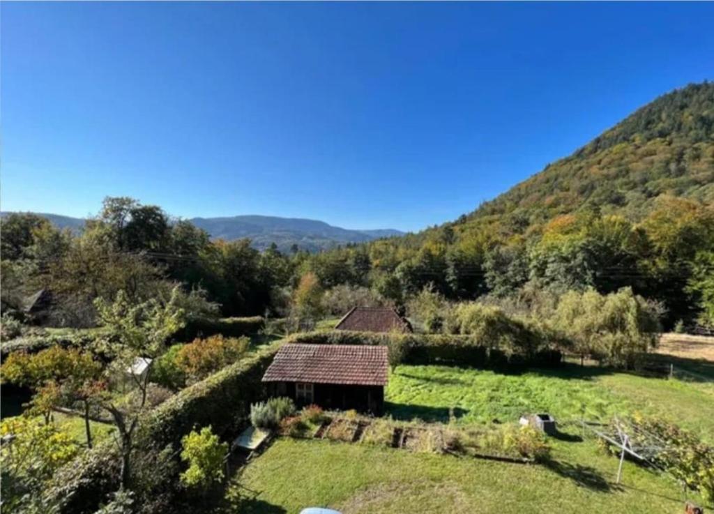 una vecchia casa in un campo con montagne sullo sfondo di De l'herbe jusqu'aux genoux - appartement 60 m2 a La Vancelle