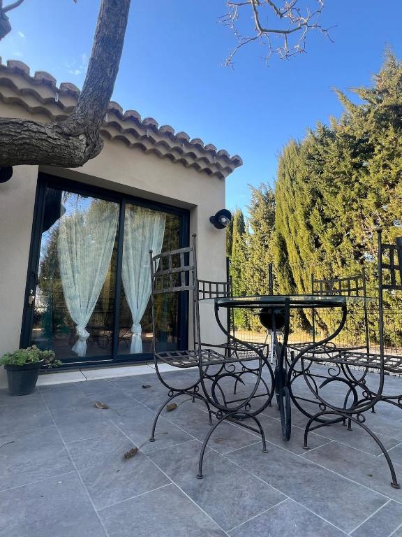 une table et des chaises devant une maison dans l'établissement Maison provençale proche du lac, à Codolet