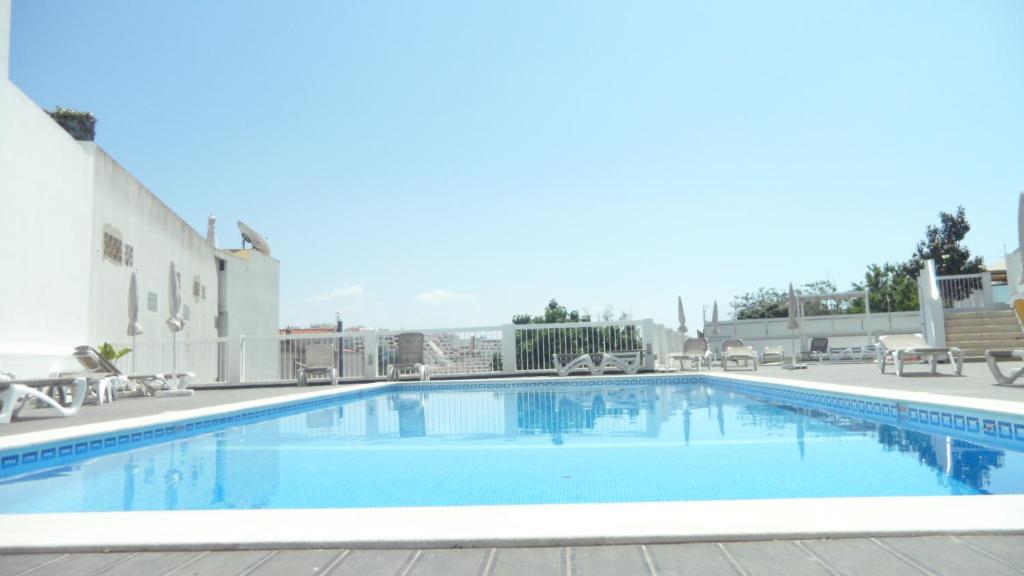 a pool at a hotel with chairs and tables at Bay View Albufeira in Albufeira