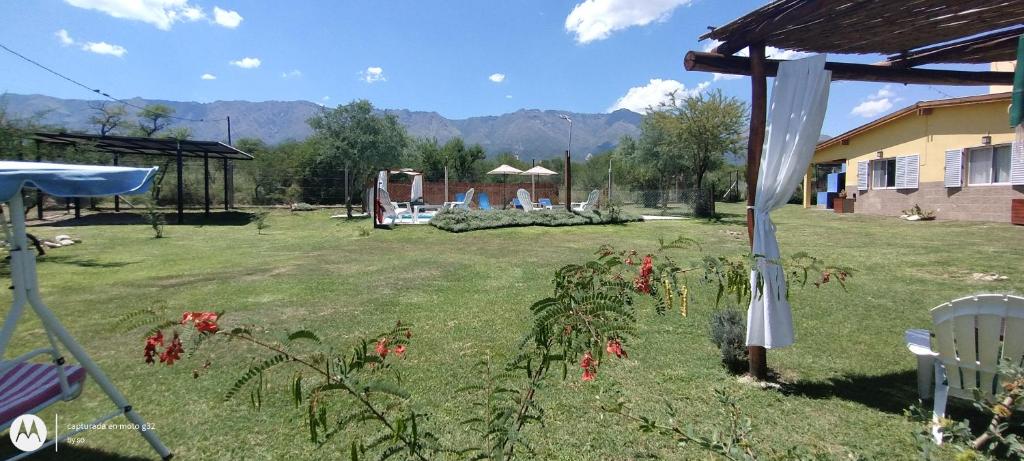a yard with a gazebo and some flowers at Cabañas Tierra del Sol in Las Rabonas