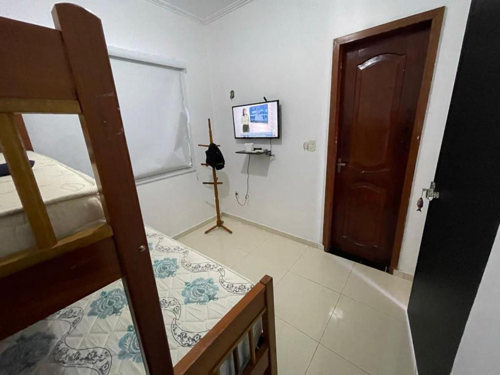 a bedroom with a bunk bed and a flat screen tv at Lazer Atalaia in Salinópolis