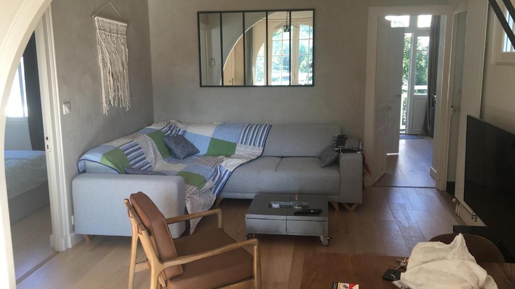 un salon avec un canapé et une table dans l'établissement 25m Plage Benoit Grands Hôtels 3p Salon 2 Chambres 65m2, à La Baule