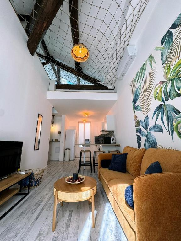 un salon avec un canapé et une table dans l'établissement Le Montmorency 56, déco rénové, proximité centre Climatisation, à Sète