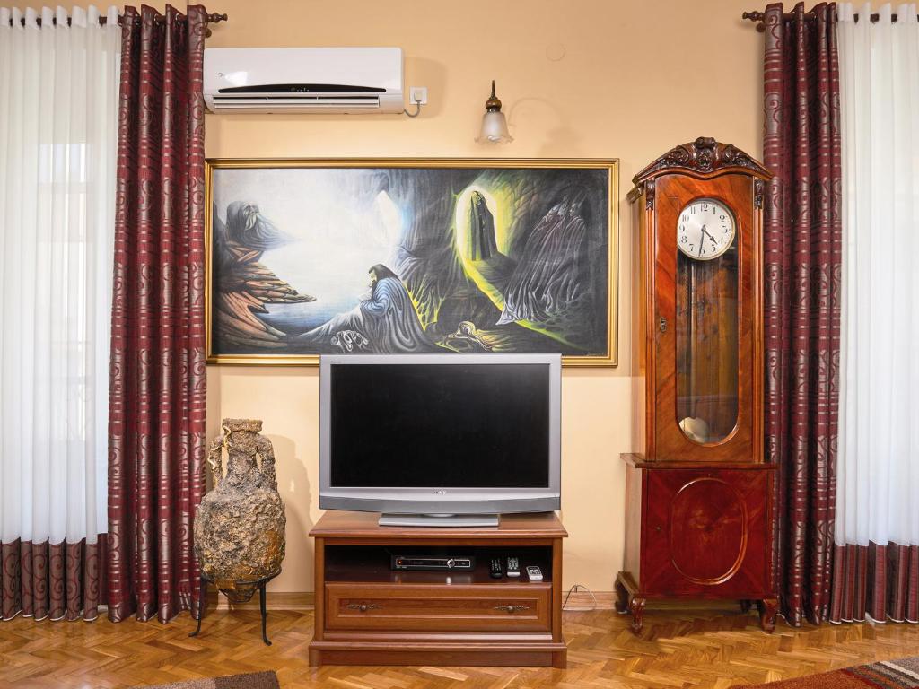 a living room with a tv and a grandfather clock at Apartment Palata Bizanti in Kotor