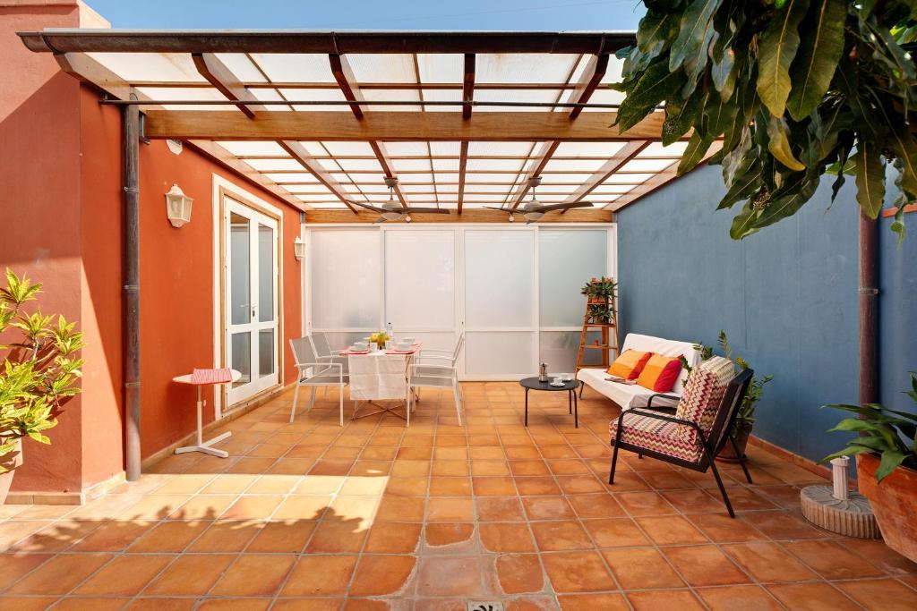 un soggiorno con patio arredato con tavolo e sedie. di Finca la Calabacera Casa Amarilla a Playa de San Juan