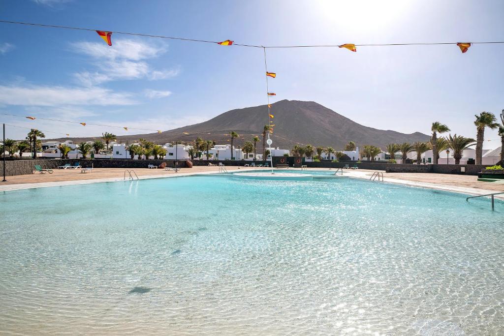 een grote plas water met een berg op de achtergrond bij El Palmeral in Playa Blanca