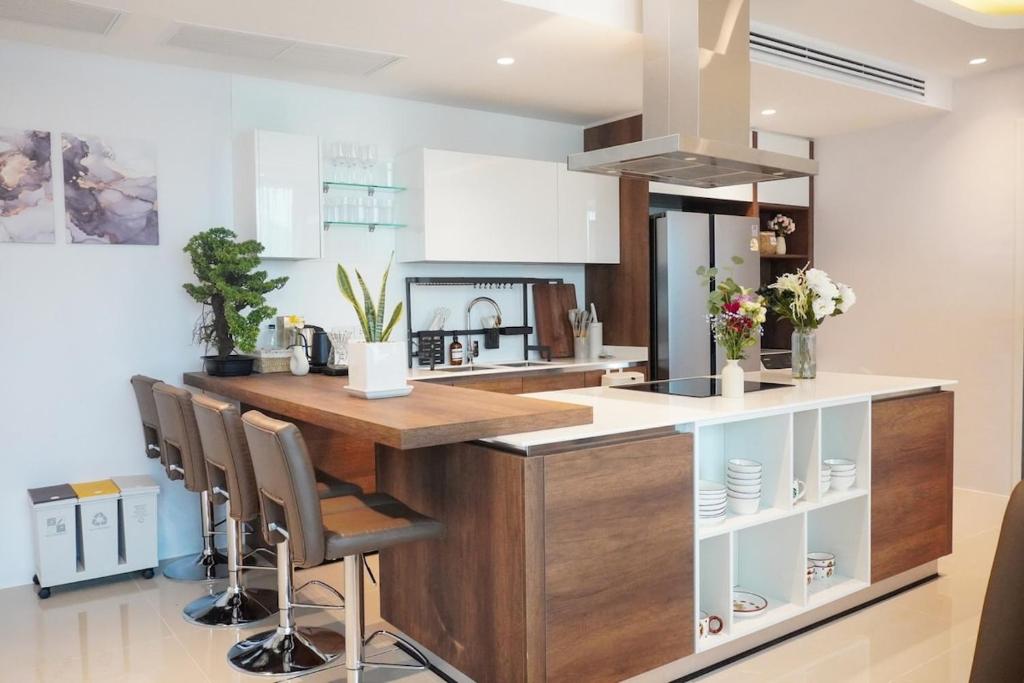 a kitchen with a large wooden counter with stools at 2BR 4Beds Luxury Condo Pool & Fitness in Phuket Town