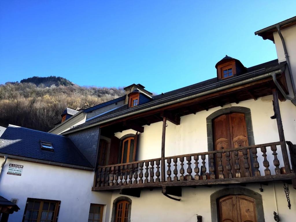 - un bâtiment blanc avec un balcon et une montagne dans l'établissement Apartement montagne dans maison de caractères, à Esterre