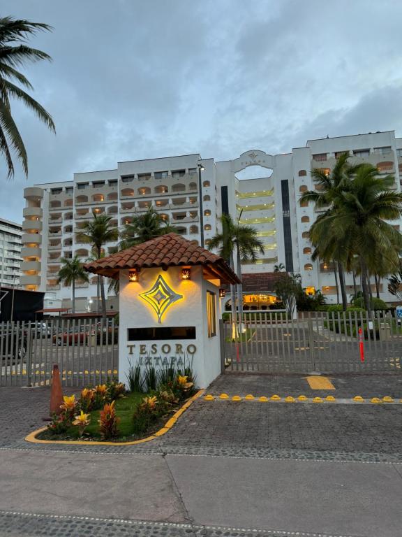 ein Gebäude mit einem Schild darauf vor Gebäuden in der Unterkunft Ixtapa zihuatanejo, Departamento vacacional- in Zihuatanejo