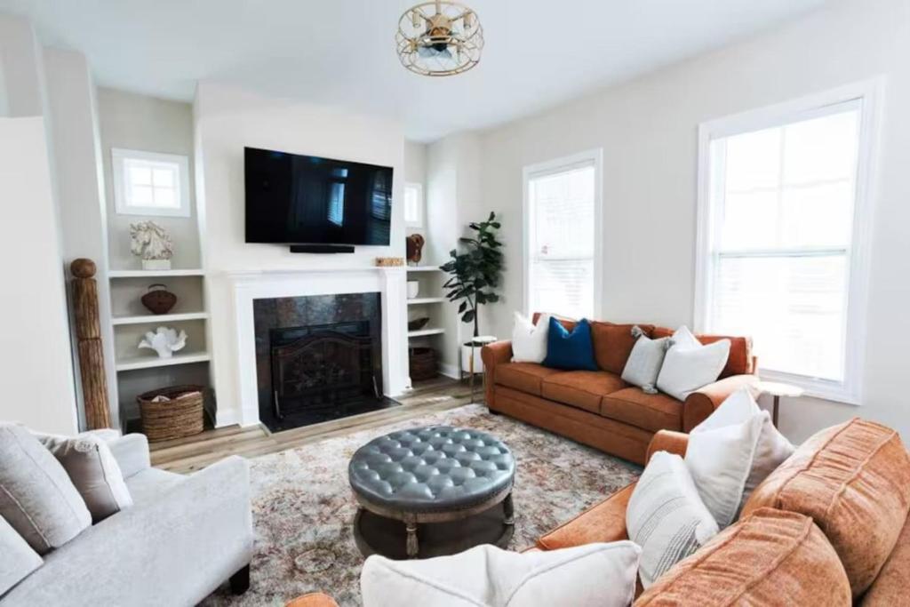 a living room with a couch and a fireplace at Pink House with Game Room - 3BR in Columbia