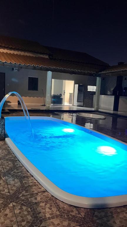 a large blue swimming pool with a water fountain at Espaço Acácia in Petrolina