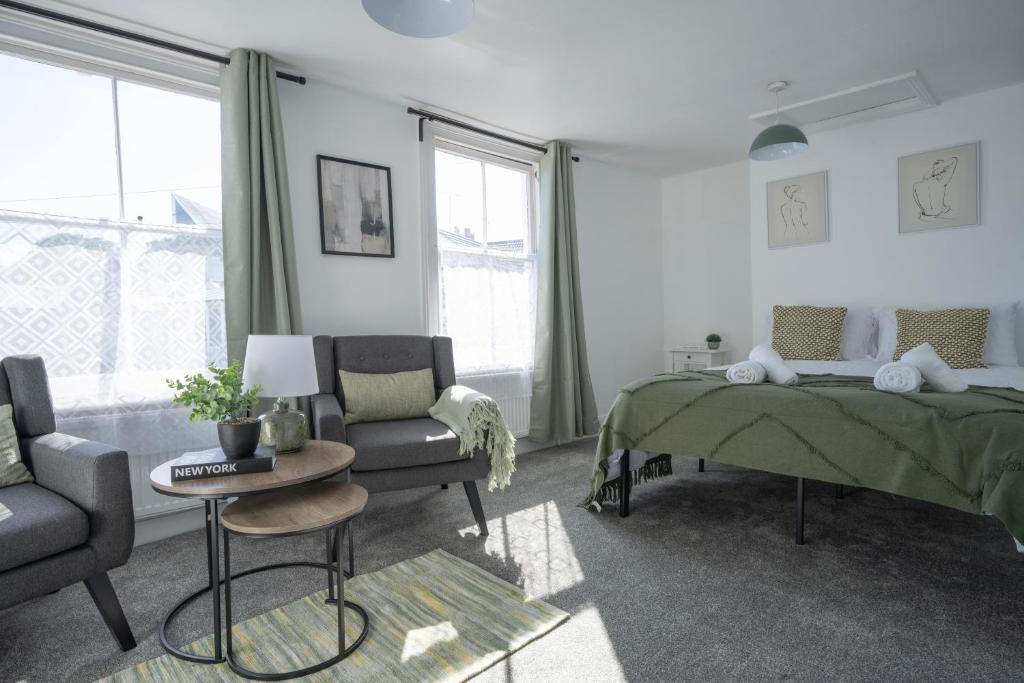 ein Schlafzimmer mit einem Bett, einer Couch und einem Sessel in der Unterkunft 4-Bedroom Central Canterbury Cottage in Kent